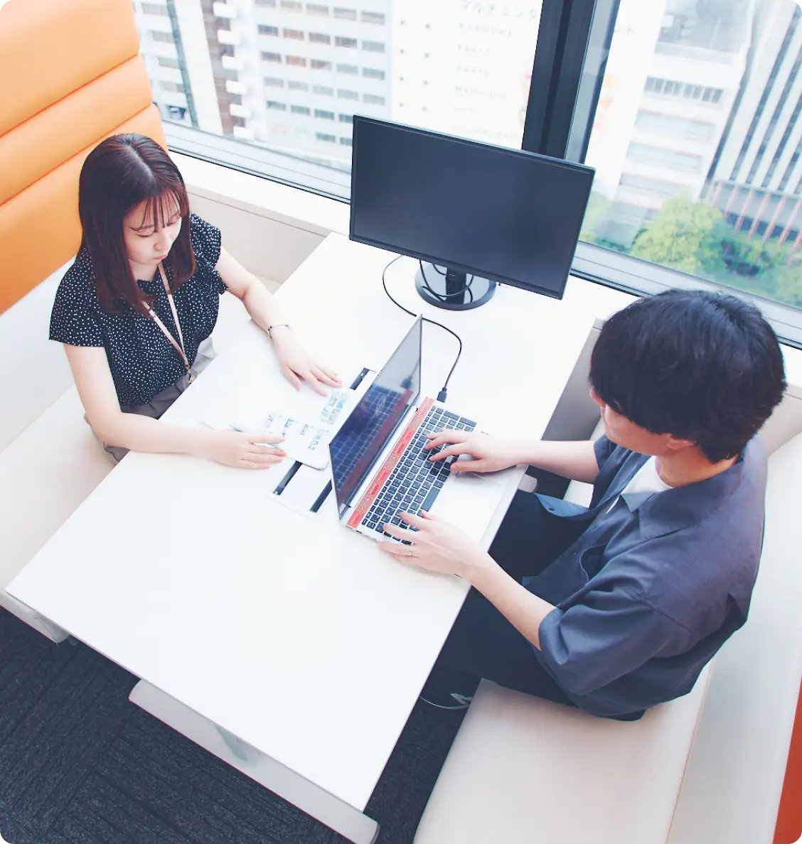 向き合ってノートパソコンを使っている男女